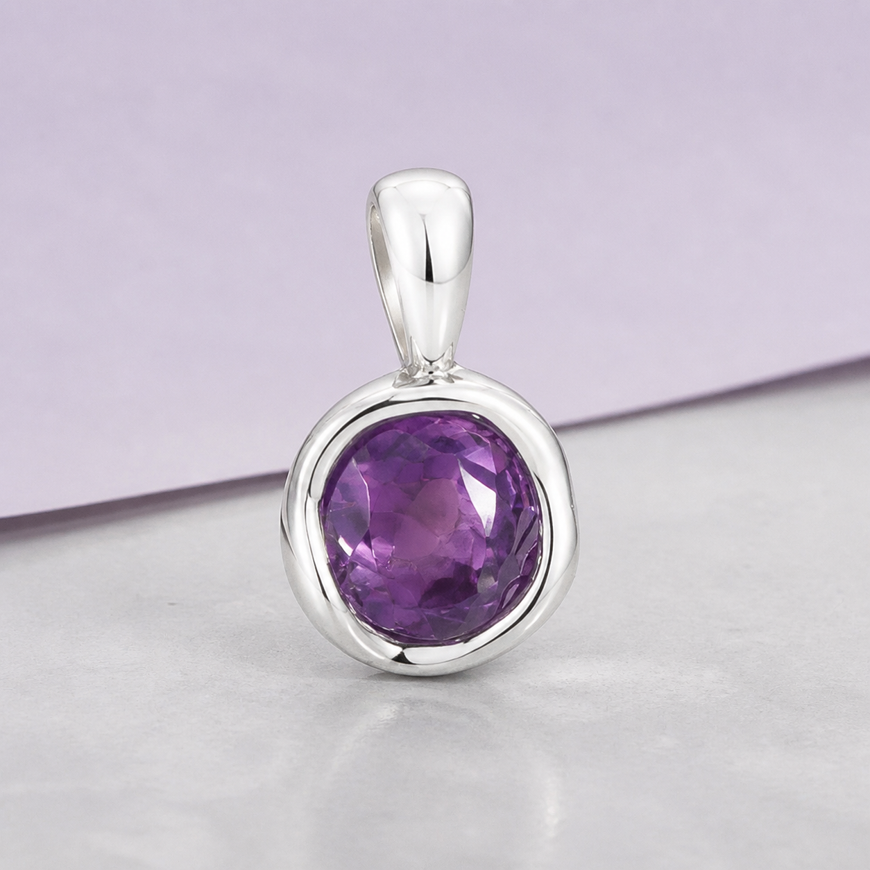 Luna Veil Amethyst Reflection pendant in a smooth silver bezel on pearl-grey