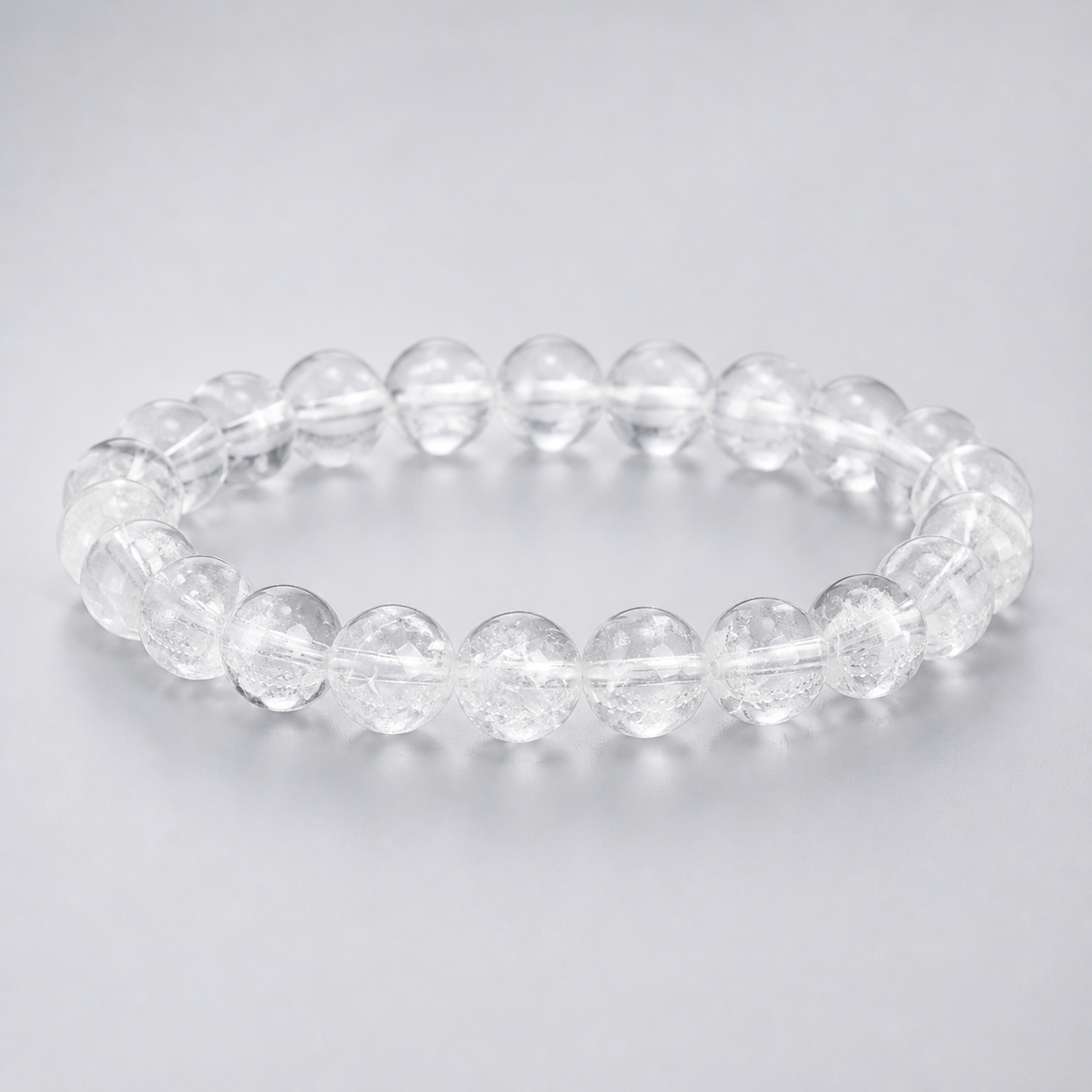 Luna Veil clear quartz round-bead bracelet on a pearl-grey studio background